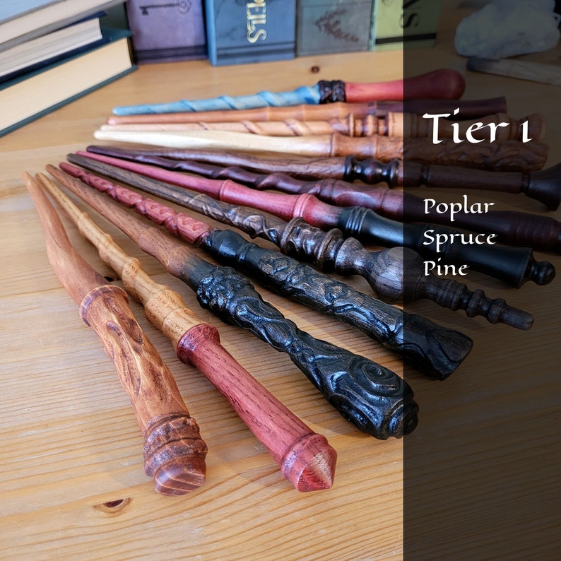 May include: A collection of handcrafted wooden wands in various colors and designs. The wands are made from poplar, spruce, and pine. Each wand features unique carvings and finishes, with a variety of handle and tip styles. The text "Tier 1" is visible.