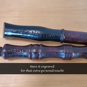 May include: Two wooden wands, one black and one burgundy, with engraved text. The black wand reads "Carpe Noctem," and the burgundy wand reads "Expecto." The image also includes the text "Have it engraved for that extra personal touch!"