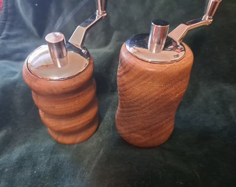 May include: Two wooden salt and pepper grinders with chrome tops and handles. The grinders have a wood grain pattern.