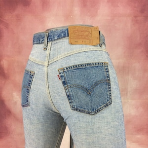 May include: Light blue denim jeans with a brown leather patch on the back waistband that says "Levi's® Original  Quality  Clothing  501®  W 31 L 32".