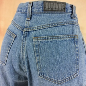 May include: A pair of blue denim jeans with a back pocket and a black leather patch that says "CITANO" on the back waistband.