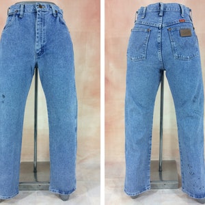 May include: A pair of light blue denim jeans with a brown leather patch on the back pocket. The jeans have a straight leg and a classic fit.