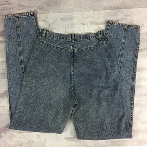 May include: Acid wash denim jeans with a high waist and a classic five-pocket design. The jeans have a straight leg cut and a faded, textured appearance. The back of the jeans is visible, showing the waistband and pockets.