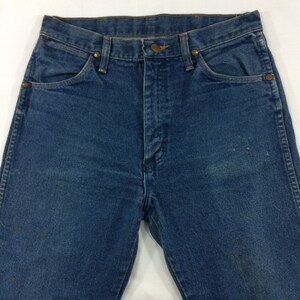 Peut inclure: Un jean bleu en denim avec un style classique &agrave; cinq poches. Le jean a une taille haute et une jambe droite.