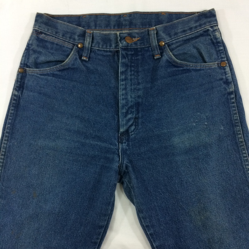 Peut inclure: Un jean bleu en denim avec un style classique &agrave; cinq poches. Le jean a une taille haute et une jambe droite.