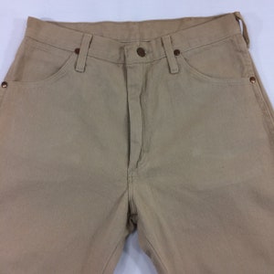 May include: A pair of light brown casual pants with a button fly and belt loops.
