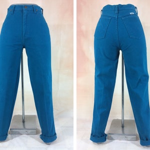 May include: A pair of high-waisted jeans in a vibrant teal blue color. The jeans have a straight leg fit and are cuffed at the bottom.