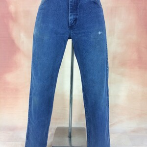 May include: A pair of blue denim jeans with a straight leg fit. The jeans have a faded look and are slightly distressed.