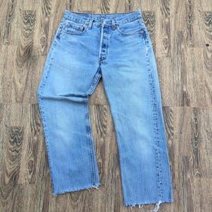 Puede incluir: Vaqueros de mezclilla azul claro con bragueta de botones y un diseño clásico de cinco bolsillos. Los vaqueros tienen un corte de pierna recta y un dobladillo deshilachado. Los vaqueros están hechos de un material de mezclilla duradero.