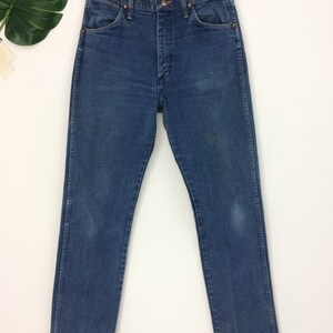 Peut inclure: Un jean bleu denim &agrave; jambe droite. Le jean a un style classique &agrave; cinq poches et une braguette &agrave; boutons.