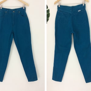 May include: A pair of high-waisted jeans in a vibrant teal blue color. The jeans have a classic straight leg fit and a button fly closure.