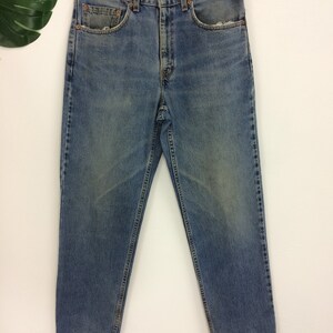 May include: A pair of light blue denim jeans with a faded wash. The jeans have a straight leg and a relaxed fit.