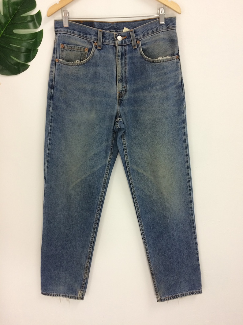 May include: A pair of light blue denim jeans with a faded wash. The jeans have a straight leg and a relaxed fit.