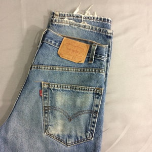 May include: A pair of blue denim jeans with a brown leather patch that reads "Levi's&reg;" and "ORIGINAL  Rivet &  Clothing Co.  San Francisco, Cal.  U.S.A.  PAT.  APR. 20, 1873.  MADE IN U.S.A.  W 32 L 32".