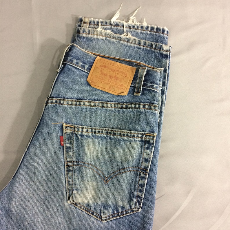 May include: A pair of blue denim jeans with a brown leather patch that reads "Levi's&reg;" and "ORIGINAL  Rivet &  Clothing Co.  San Francisco, Cal.  U.S.A.  PAT.  APR. 20, 1873.  MADE IN U.S.A.  W 32 L 32".