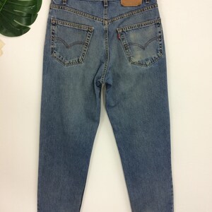 May include: A pair of light blue denim jeans with a brown leather patch on the back. The jeans have a classic five-pocket style and a straight leg.