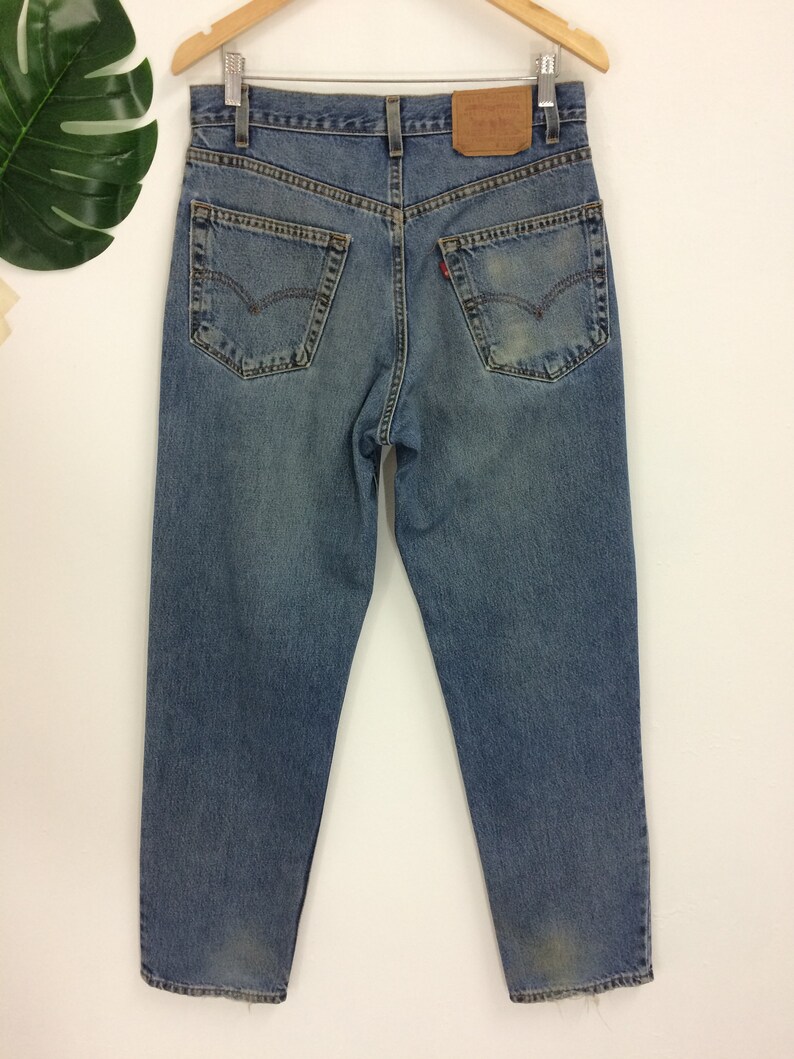 May include: A pair of light blue denim jeans with a brown leather patch on the back. The jeans have a classic five-pocket style and a straight leg.