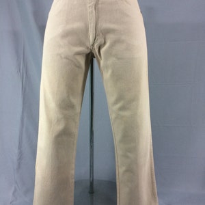 May include: A pair of light beige straight-leg jeans with a classic five-pocket design.