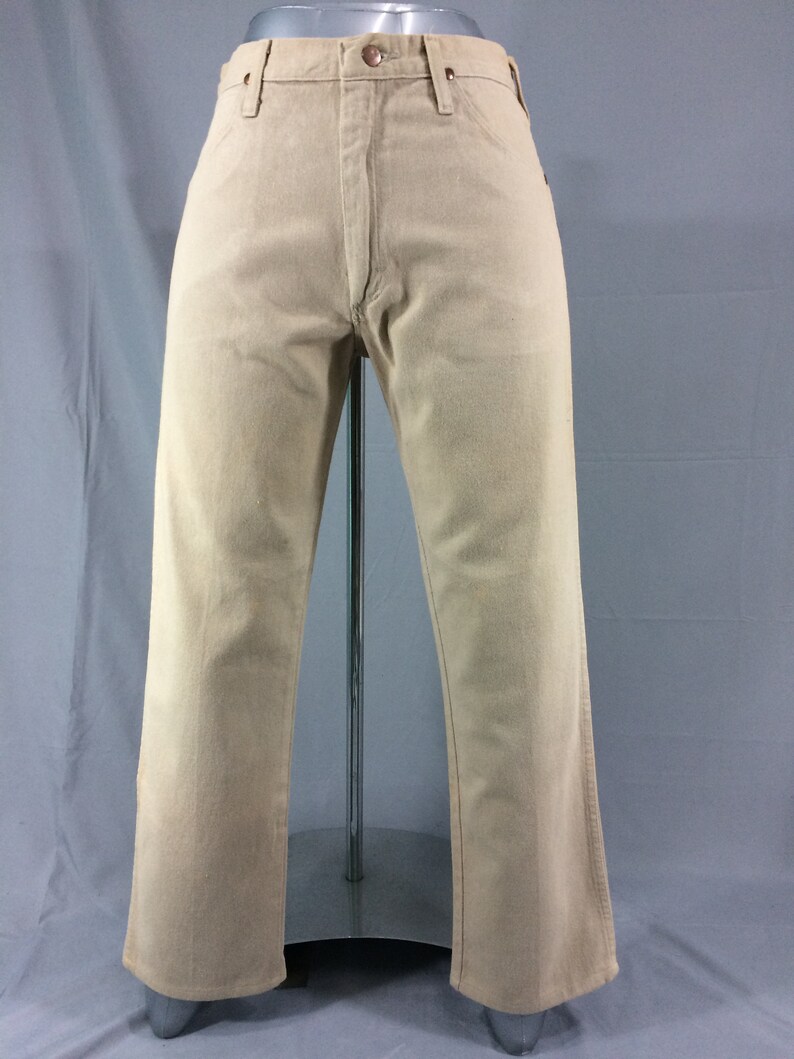 May include: A pair of light beige straight-leg jeans with a classic five-pocket design.