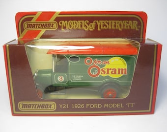 May include: A green Matchbox Models of Yesteryear die-cast toy truck with a red roof and "O for an Osram" printed on the side. The truck is a 1926 Ford Model TT.