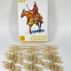 Puede incluir: Una caja de kits de modelos de plástico para 12 figuras de caballería pesada persa a escala 1/72. La caja muestra una pintura de un guerrero montado con armadura roja y dorada. El kit incluye piezas de plástico sin pintar para las figuras y los caballos.