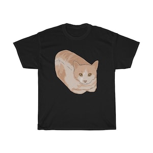 Puede incluir: Una camiseta negra con un gráfico de un gato con forma de pan.