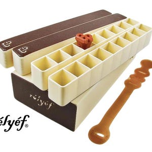 May include: A white and brown plastic storage box with a removable lid and a brown label that says "r&eacute;ly&eacute;f". The box has 24 compartments and is designed to hold small items. A brown plastic tool is also included.