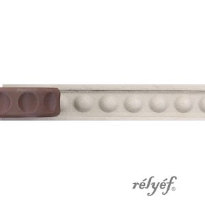 Op de afbeelding: Een lichtbeige, lineaire sierlijst met een herhalend patroon van verhoogde, halfronde stippen over de lengte. Een bruin, rechthoekig gereedschap met cirkelvormige inkepingen is aan de linkerkant geplaatst. De tekst "rélyéf" is zichtbaar.