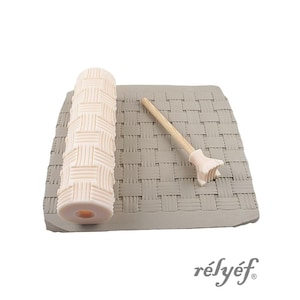 Puede incluir: Un rodillo de textura para arcilla cilíndrico de color beige claro y una pequeña herramienta manual a juego con mango de madera, ambos con un patrón de tejido de cesta, sobre una losa de arcilla gris rectangular con el mismo patrón.