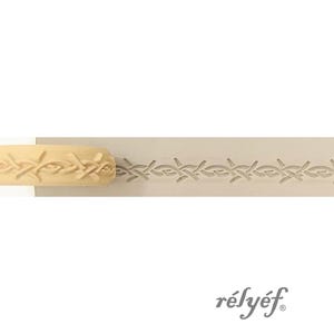 May include: A light-coloured, wooden rolling pin featuring a repeating leaf and vine pattern. The pattern is embossed, creating a textured design. The word "rélyéf" is printed in a script font.