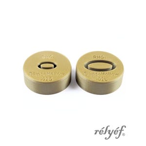 May include: Two tan, circular objects with an oval cutout in the center. The text "PKG-" and "Ellipse Hollow -02S" is printed on one object. The other object has "RHG-" and "Ellipse Hollow -02L" printed on it. The brand name "rélyéf" is in the bottom right.