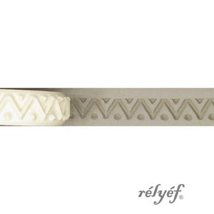 Puede incluir: Primer plano de un objeto cilíndrico blanco con un patrón de chevrón repetido y un molde rectangular gris con un diseño similar. La palabra "rélyéf" está impresa en gris.