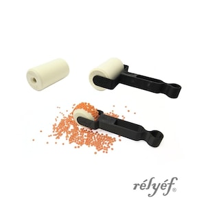 May include: Three craft tools with white rollers and black handles are shown against a white backdrop. One roller is separate, while the other two are attached to the handles. Small orange beads are scattered around one of the rollers. The word "rélyéf" is printed in the bottom right corner.