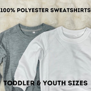 May include: Two long-sleeved sweatshirts, one grey and one white, with the text "100% POLYESTER SWEATSHIRTS" and "TODDLER & YOUTH SIZES" printed on them.
