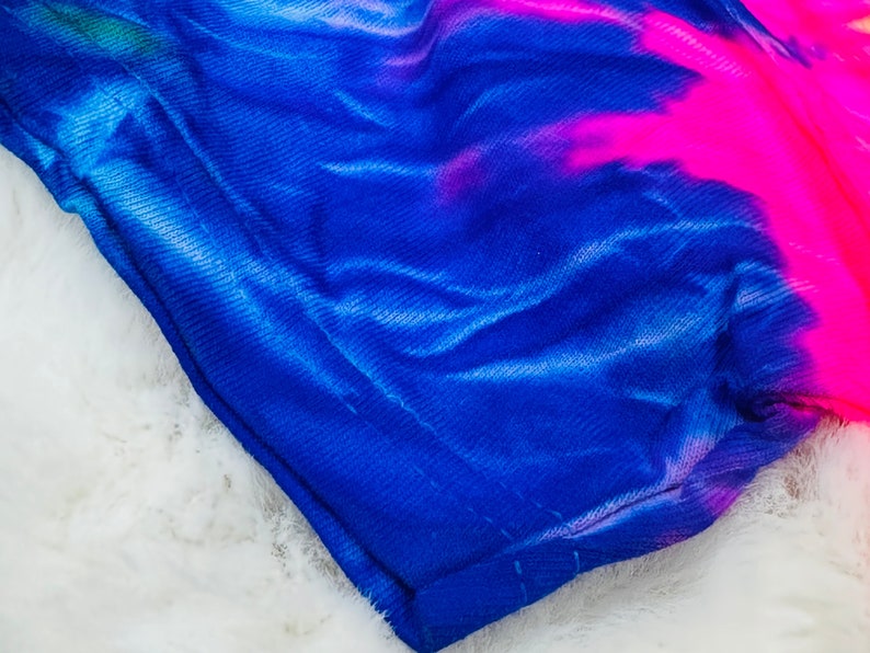 May include: A blue and pink tie-dye fabric with a textured surface.