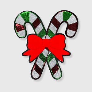 May include: Two sequined candy canes with a red bow. The candy canes have alternating green, white, and red stripes. The bow is a bright red color. The edges of the candy canes and bow are outlined in black.