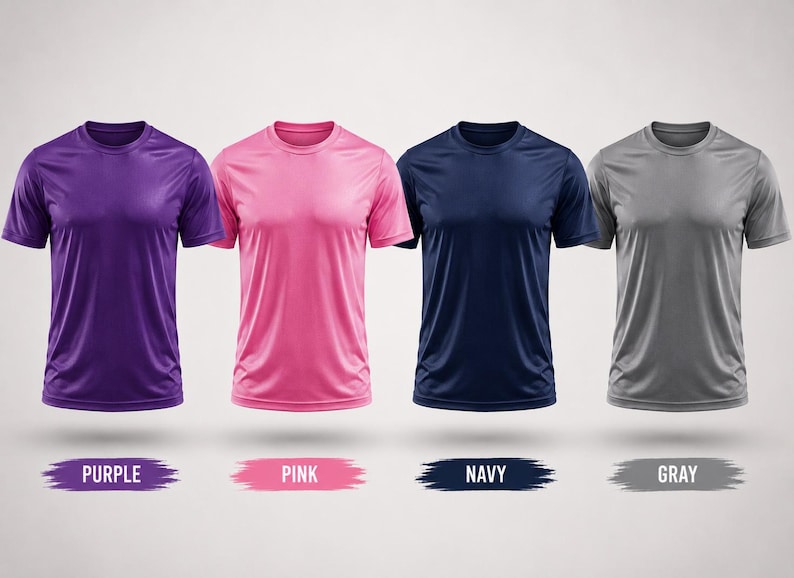 May include: Four short-sleeved crew neck t-shirts in purple, pink, navy blue, and gray. Each shirt is displayed with a corresponding color label underneath, reading PURPLE, PINK, NAVY, and GRAY, presented on a plain light background.