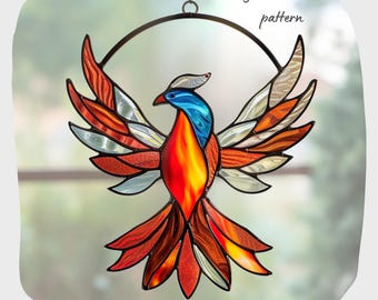 May include: A stained glass pattern of a phoenix with red, orange, yellow, blue and white glass pieces. The phoenix is suspended from a metal ring.