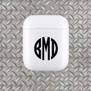May include: White wireless charging case with a black circle monogram sticker that says "BMD" on it.