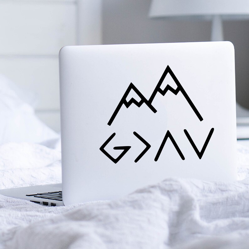 May include: A white laptop with a black sticker of mountains and the text "G>A>V" on the lid.