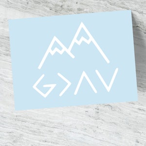 May include: A light blue background with a white mountain range graphic and the text "God is greater than the highs and lows".