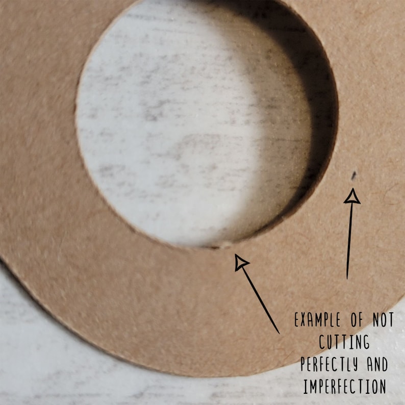 May include: Close-up of a tan cardboard cutout with a circular hole. The text "EXAMPLE OF NOT CUTTING PERFECTLY AND IMPERFECTION" is written in black. Arrows point to imperfections in the cut, highlighting the handmade nature.