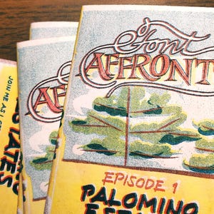 Puede incluir: Mini fanzines apilados con el título "Font Affronts" en un estilo vintage. La portada presenta una escena de árboles estilizada y el texto "Episode 1 Palomino Estates". Los fanzines forman parte de una mini serie.