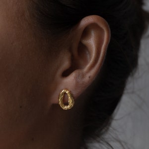Peut inclure: Boucles d'oreilles ovales textur&eacute;es en or. Les boucles d'oreilles sont petites et d&eacute;licates.