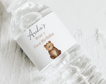 May include: A clear plastic water bottle with a white label featuring the text "Archie's Bear's First Birthday" and a brown bear illustration. A matching label is below the bottle.