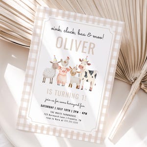 Könnte beinhalten: Eine beige und weiß karierte Einladung mit dem Text "oink, cluck, baa & moo! OLIVER IS TURNING 1!" zeigt Aquarellillustrationen von Hoftieren. Die Einladung liegt auf einem weißen Teller mit einem getrockneten Palmblatt.
