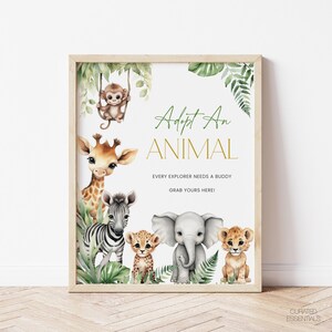 May include: A framed print with watercolor illustrations of jungle animals, including a monkey, giraffe, zebra, cheetah, elephant, and lion. The text reads "Adopt An Animal" and "Every Explorer Needs a Buddy, Grab Yours Here!"