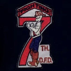 May include: A red and white embroidered patch with a cartoon firefighter holding a hose. The patch says "Fighting 7th D.F.D."