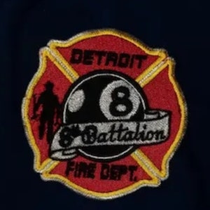May include: Red and yellow embroidered patch with a black 8-ball and the text "Detroit 8 Battalion Fire Dept."