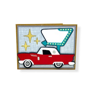 May include: A retro-style greeting card featuring a red classic car with a white roof, set against a light blue background with gold star accents. A teal arrow-shaped sign with a blank white space and yellow lights completes the design.